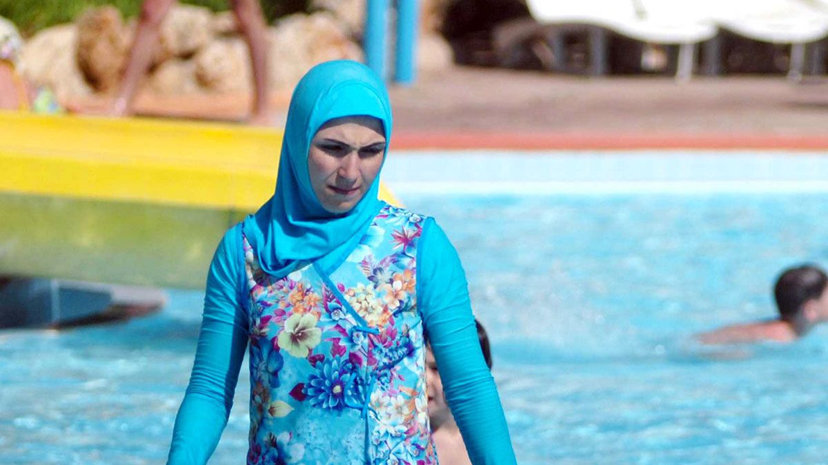 Una mujer se baña en una piscina llevando el polémico ‘burkini’ que ha sido prohibido en muchas playas de Francia.