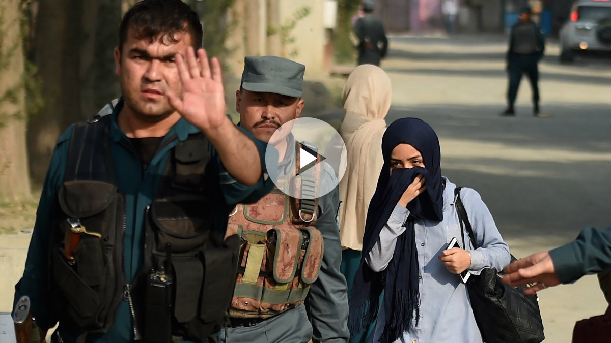 Una estudiante de la Universidad Americana de Kabul abandona el lugar de los hechos escoltada por miembros de las Fuerzas de Seguridad. (Foto: AFP)