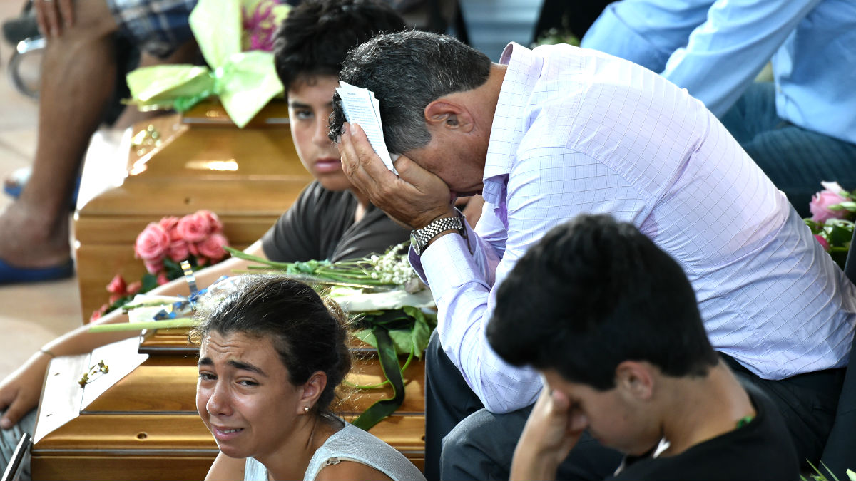 Varias personas lloran por las víctimas del terremoto durante el funeral (Foto: AFP).