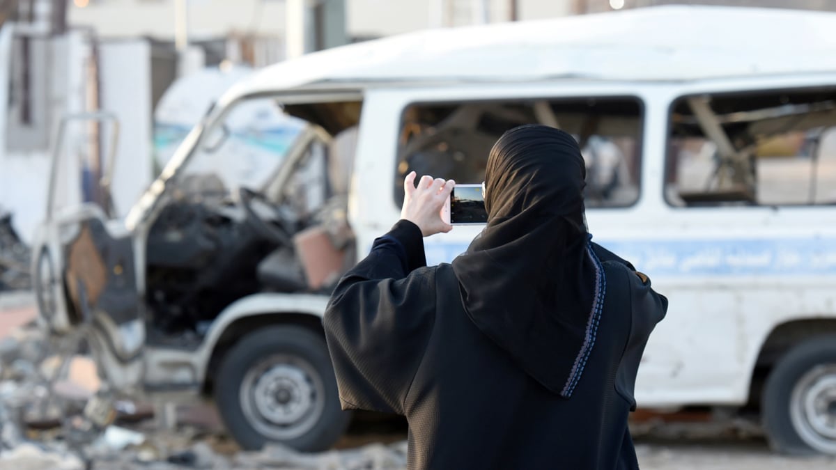 Una mujer fotografía los daños de un atentado en Yemen. (Foto: AFP)
