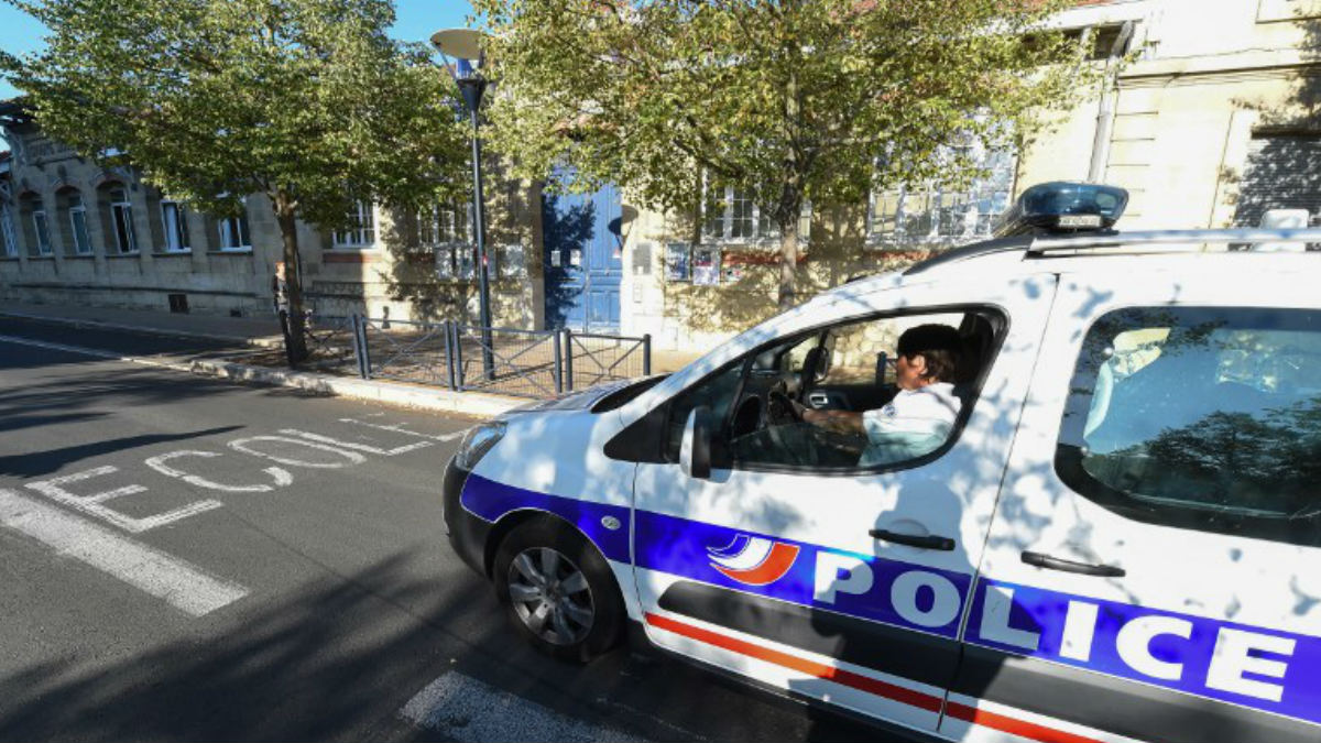 Un coche de policía a la entrada de un Colegio. AFP