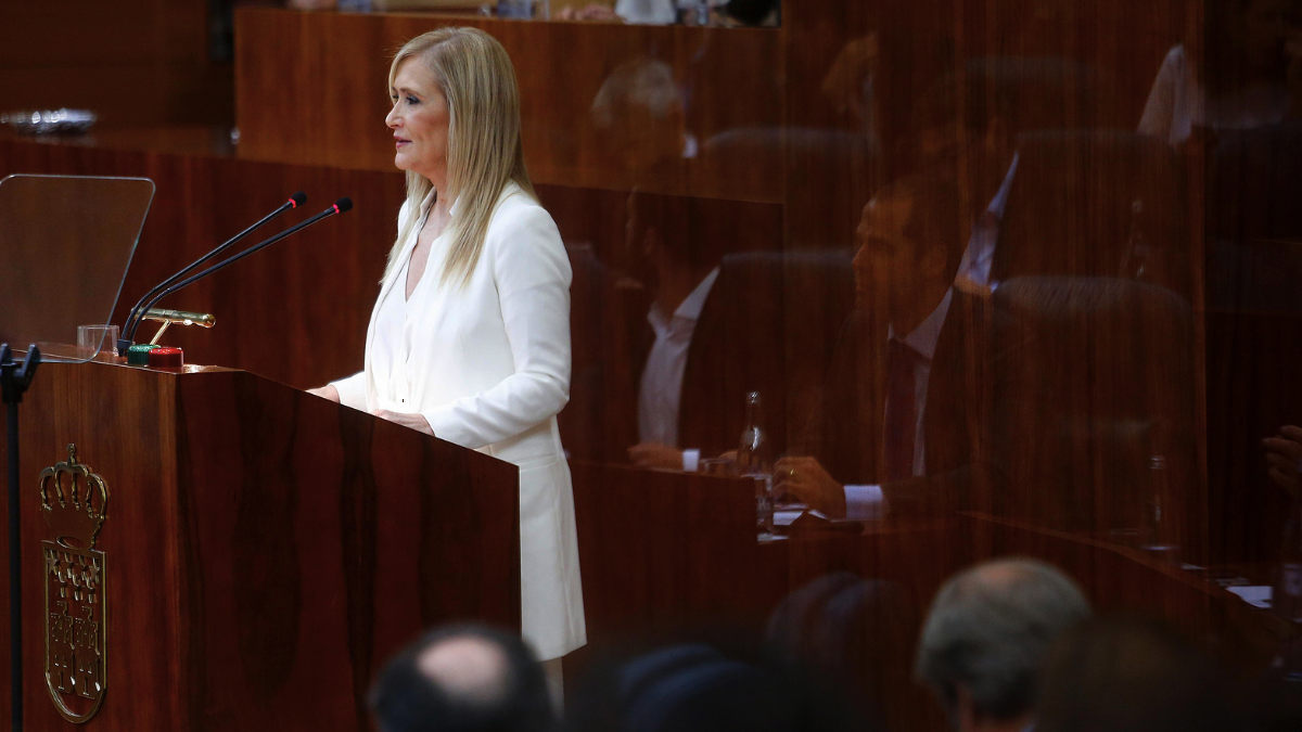 La presidenta Cristina Cifuentes durante su discurso con el reflejo de Ignacio Aguado, portavoz de Ciudadanos. (Foto: CAM)