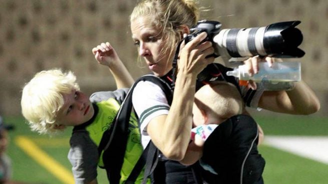 Una fotógrafa se hace viral por una imagen con sus dos hijos a cuestas en pleno partido de rugby