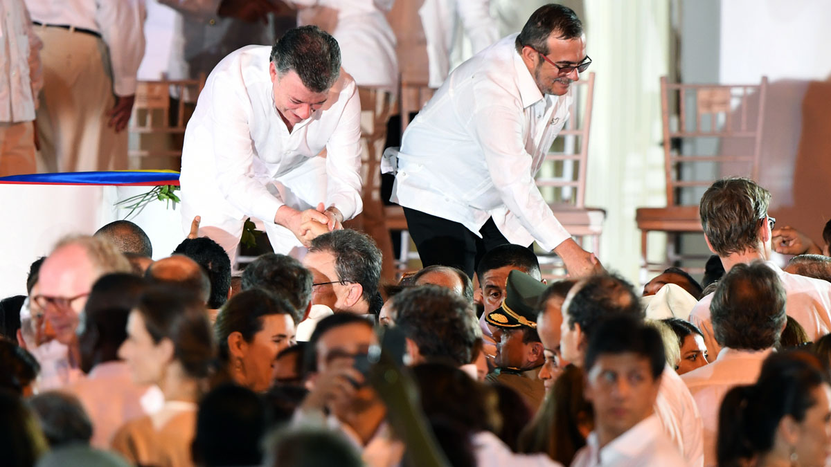 Juan Manuel Santos y Timochenko, de las FARC, tras firmar el pacto en Cartagena (Foto: AFP)