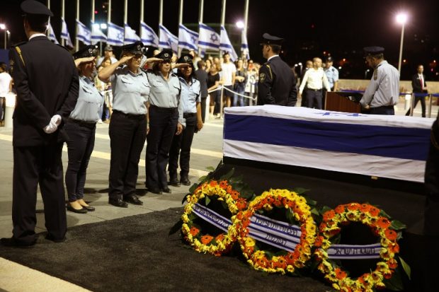 Mujeres integrantes del equipo de la Policía israelí presentan sus respetos ante el féretro de Simon Peres. AFPThousands of Israelis braved tight security and streamed into a plaza outside Israel's parliament to have a few seconds to bow, pray and take a picture before the flag-draped coffin of ex-president Shimon Peres. / AFP PHOTO / Gali TIBBON