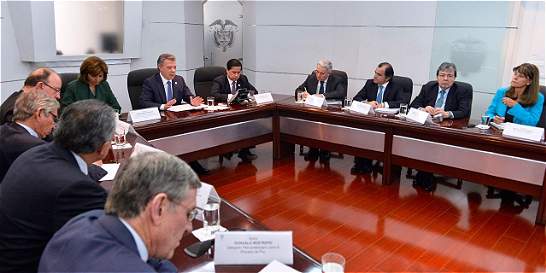 El presidente Santos, al frente de la reunión, y Álvaro Uribe, en la esquina superior, este miércoles en la Casa de Nariño.