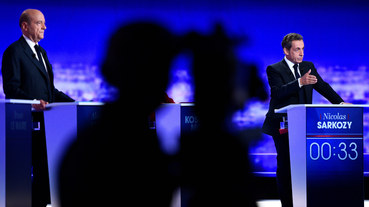 Alain Juppé y Nicolas Sarkozy al fondo, durante el debate de Los Republicanos. (AFP)