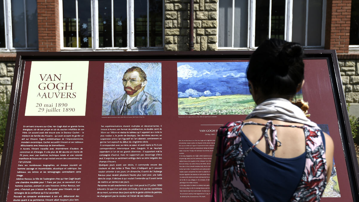 Una mujer lee un cartel alusivo a Van Gogh (Foto: AFP).