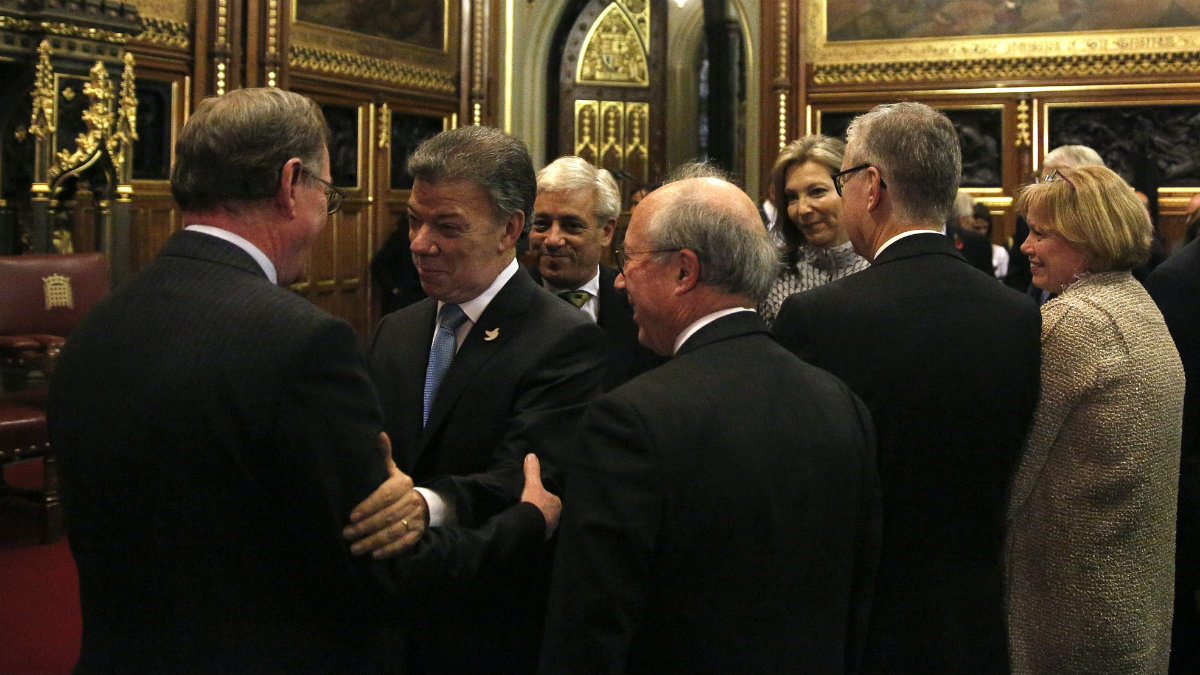 Juan Manuel Santos saluda al también Nobel de la Paz David Trimble en el Parlamento de Westminster. (AFP)