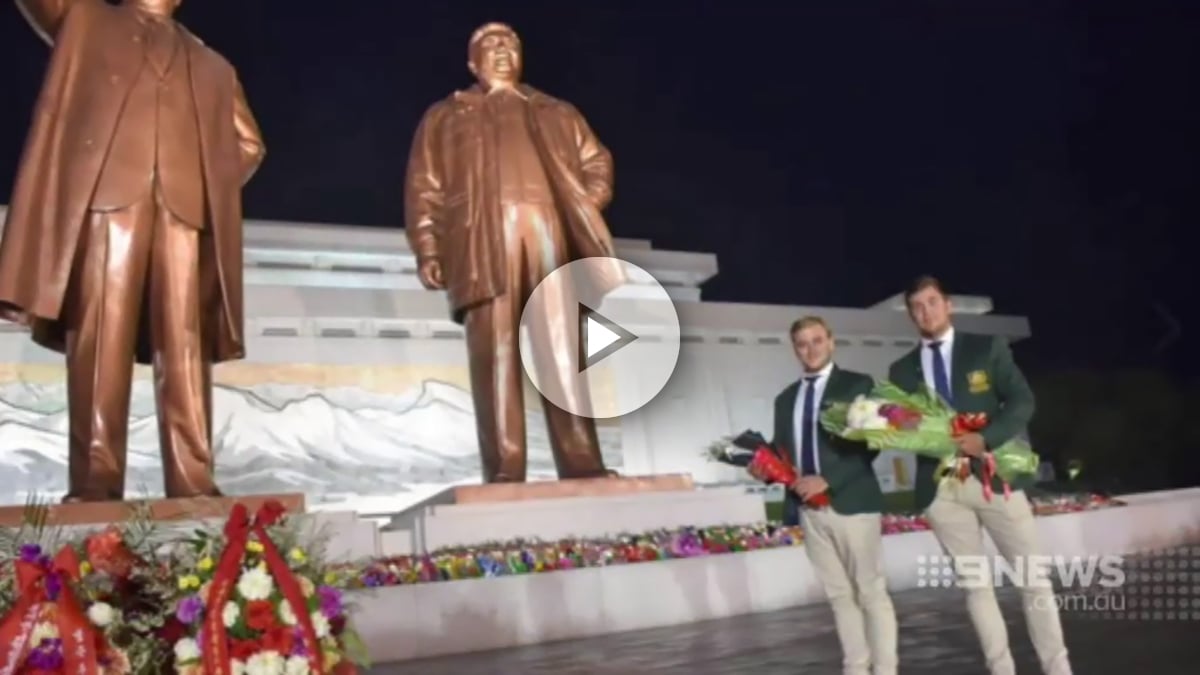 Los dos australianos posando entre risas ante las estatuas de los dictadores norcoreanos.