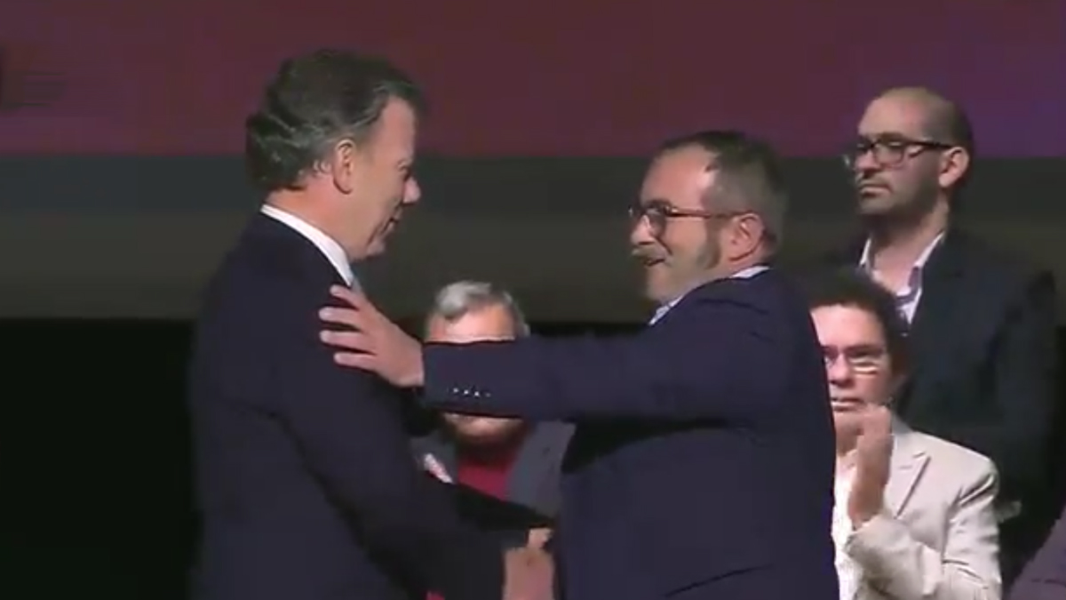 Juan Manuel Santos y el terrorista Timochenko se abrazan tras la firma del acuerdo.