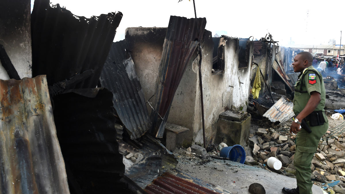 Un policía nigeriano ante unos edificios destruidos (Foto: AFP).