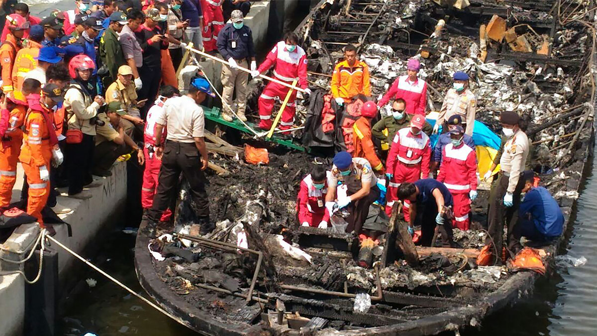 Los investigadores y equipos de rescate inspeccionan el barco siniestrado. (Foto: AFP)