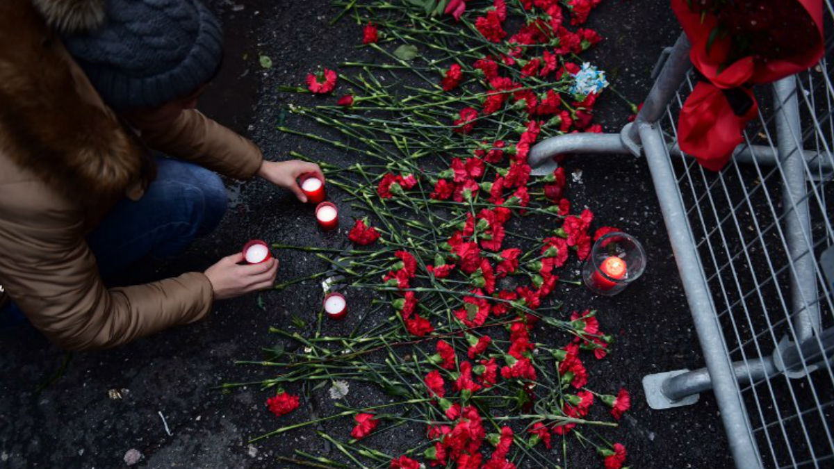 Una mujer deposita una vela en un improvisado memorial por las víctimas del atentado en frente de la discoteca Reina, donde tuvo lugar la matanza. Foto: AFP