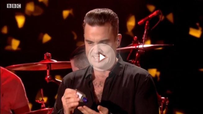 El cantante Robbie Williams se desinfecta las manos tras saludar a unos fans