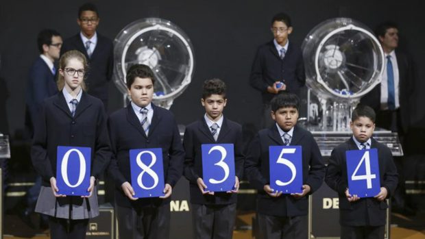 Los niños de San Ildefonso con los números premiados de el primer premio de 'El Niño' de 2017. Foto: EFE