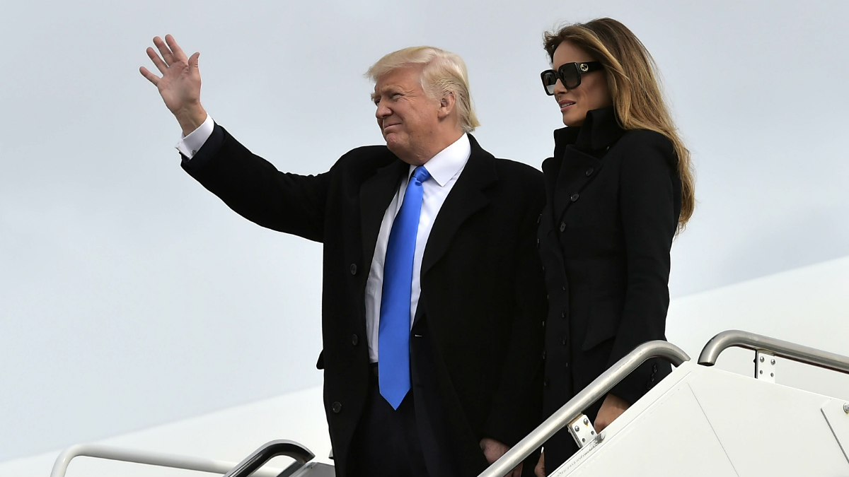 Donald Trump, junto a su esposa, saluda a su llegada al aeropuerto de Washington. (AFP)