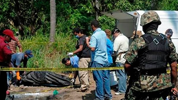 Los investigadores extraen restos humanos de la fosa hallada en Cerro del Fraile, Nuevo Léon (México).