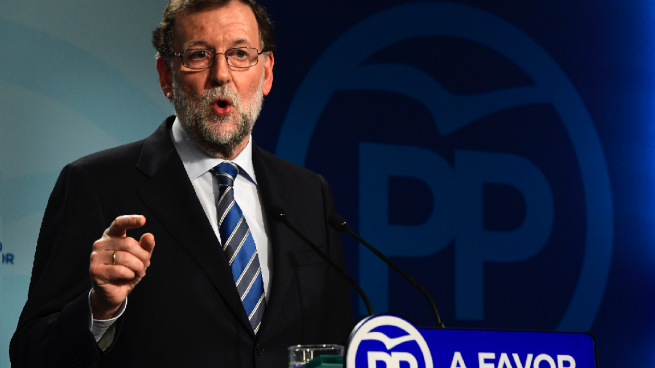 El líder del PP, Mariano Rajoy, junto al logo de la gaviota. (Foto: AFP)