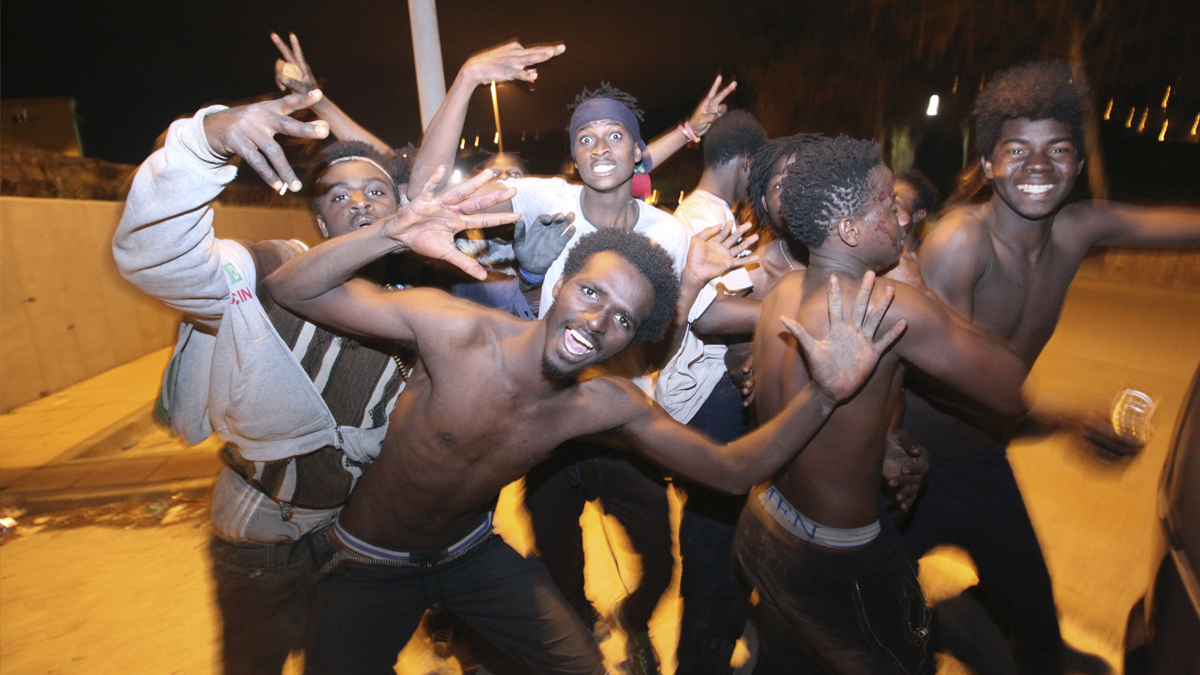 Inmigrantes tras superar la valla de Ceuta. (Foto: EFE)