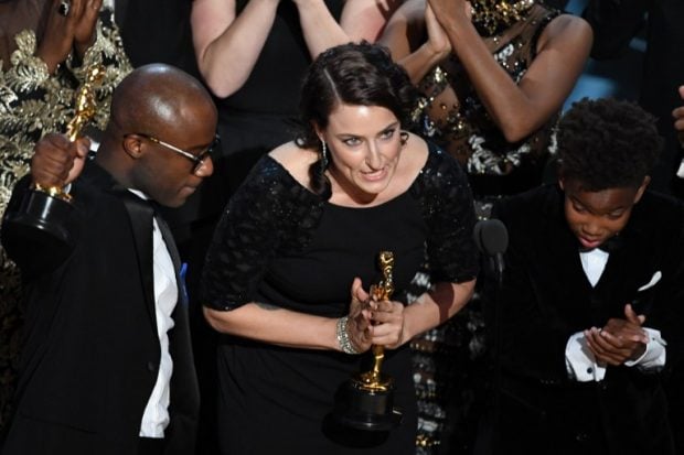 El director de 'moonlight' Barry Jenkins y la productora Adele Romanski junto al actor Alex R Hibbert celebran la victoria a Mejor Película. Foto: AFP