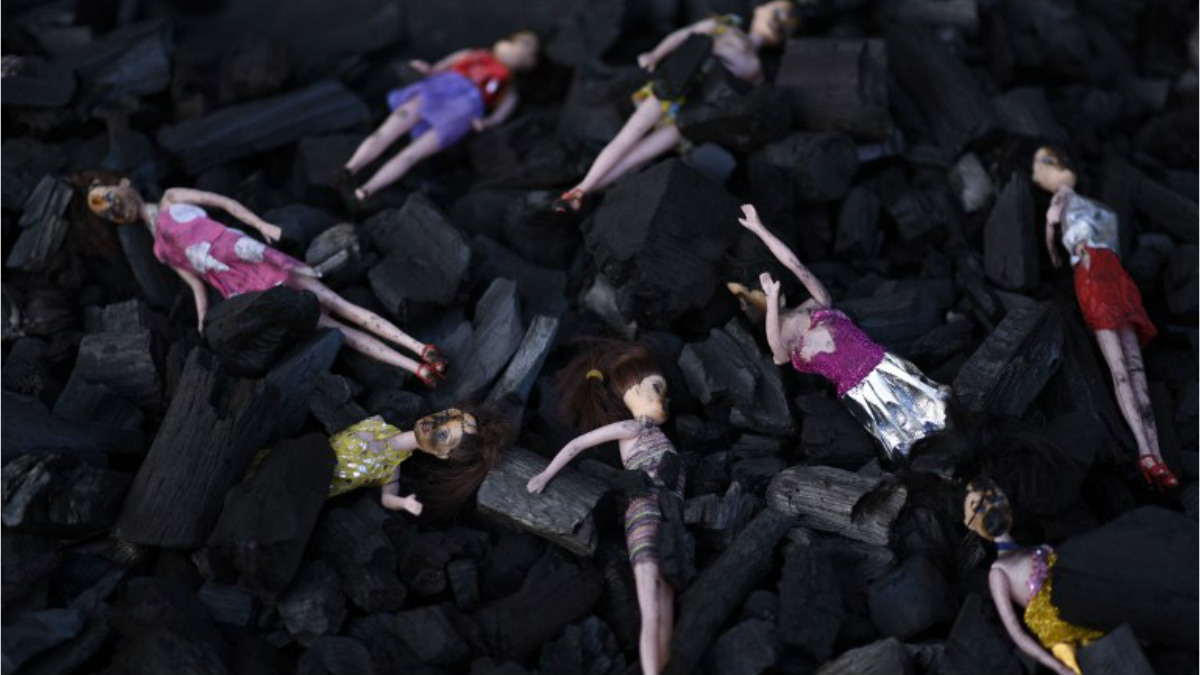 Unas muñecas componen el improvisado homenaje a las víctimas del incendio en el centro de menores de Guatemala. Foto: AFP