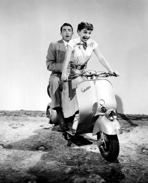 Audrey Hepburn y Gregory Peck son los protagonistas de 'Vacaciones en Roma', película en la que ambos dan el mítico paseo en Vespa por la ciudad eterna. 