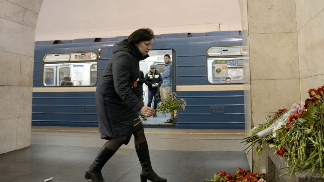 Una mujer deposita flores donde sucedió la masacre en el metro de San Petersburgo (AFP)
