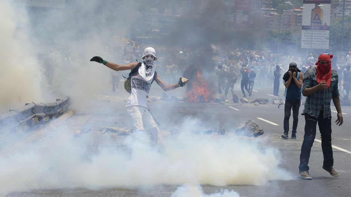 Un manifestante devuelve un bote de gas lacrimógeno lanzado por la policía. (Foto: AFP)