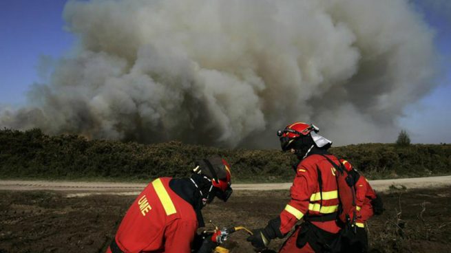 Efectivos de Bomberos durante las labores de extinción del incendio que ayer se inició en el municipio coruñés de Narón y que en las últimas horas alcanzó la parroquia rural de Covas, en Ferrol, y que permanece activo, aunque ya está bajo control, según informó hoy el ayuntamiento ferrolano. Foto: EFE