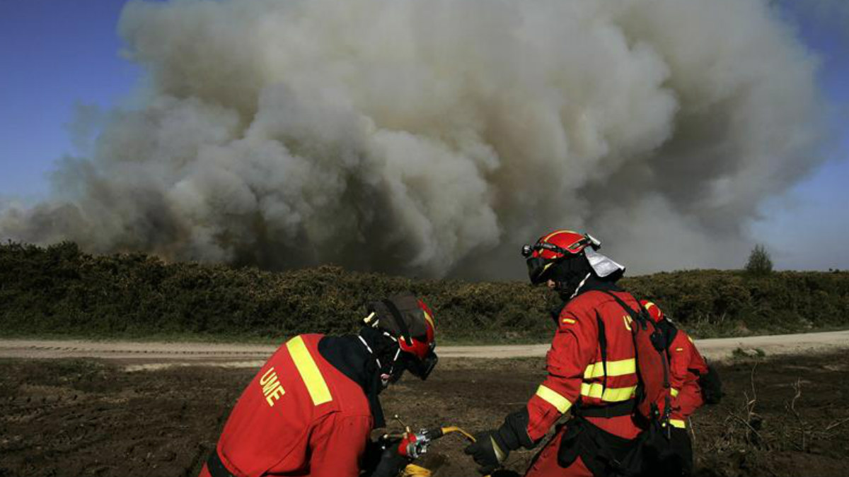 Efectivos de Bomberos durante las labores de extinción del incendio que ayer se inició en el municipio coruñés de Narón y que en las últimas horas alcanzó la parroquia rural de Covas, en Ferrol, y que permanece activo, aunque ya está bajo control, según informó hoy el ayuntamiento ferrolano. Foto: EFE