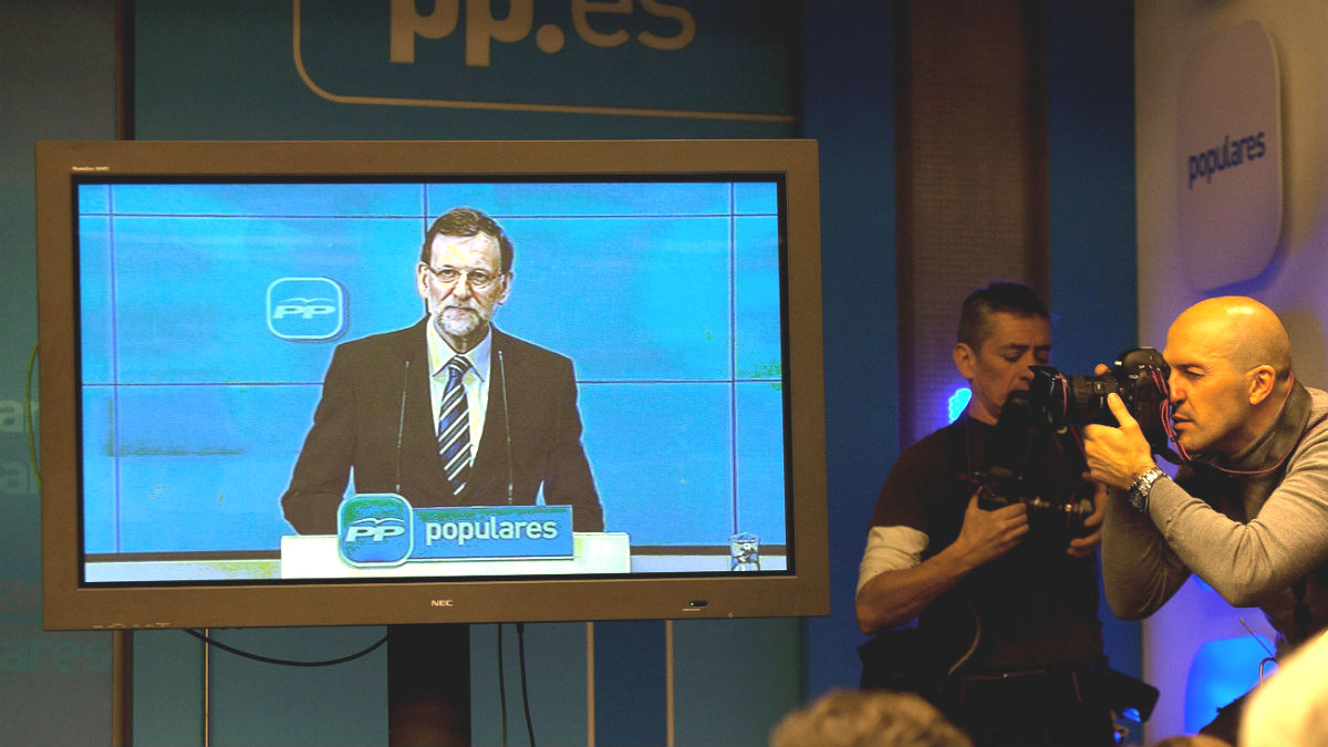 Un discurso de Mariano Rajoy ante la junta directiva del PP, seguido por la prensa a través de plasma.