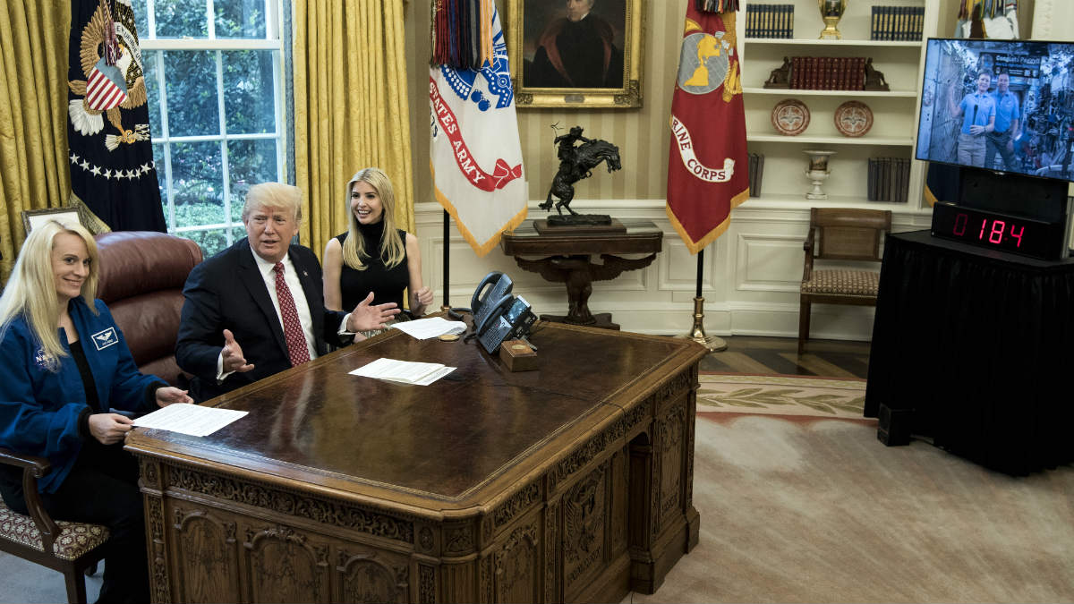 Trump, junto a su hija iVanka y la astronauta Kate Rubins, en el despacho oval, hablando con Peggy Whitson, en la ISS. (AFP)