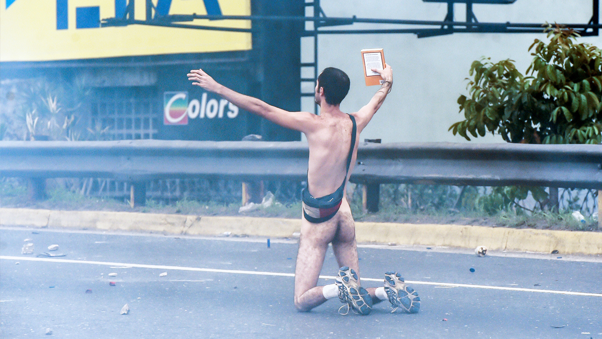 Un manifestante se enfrenta a las fuerzas de seguridad de Maduro en Caracas. (AFP)