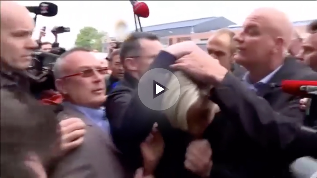 Marine Le Pen, protegida por su equipo de seguridad mientras varios manifestantes le lanzan huevos