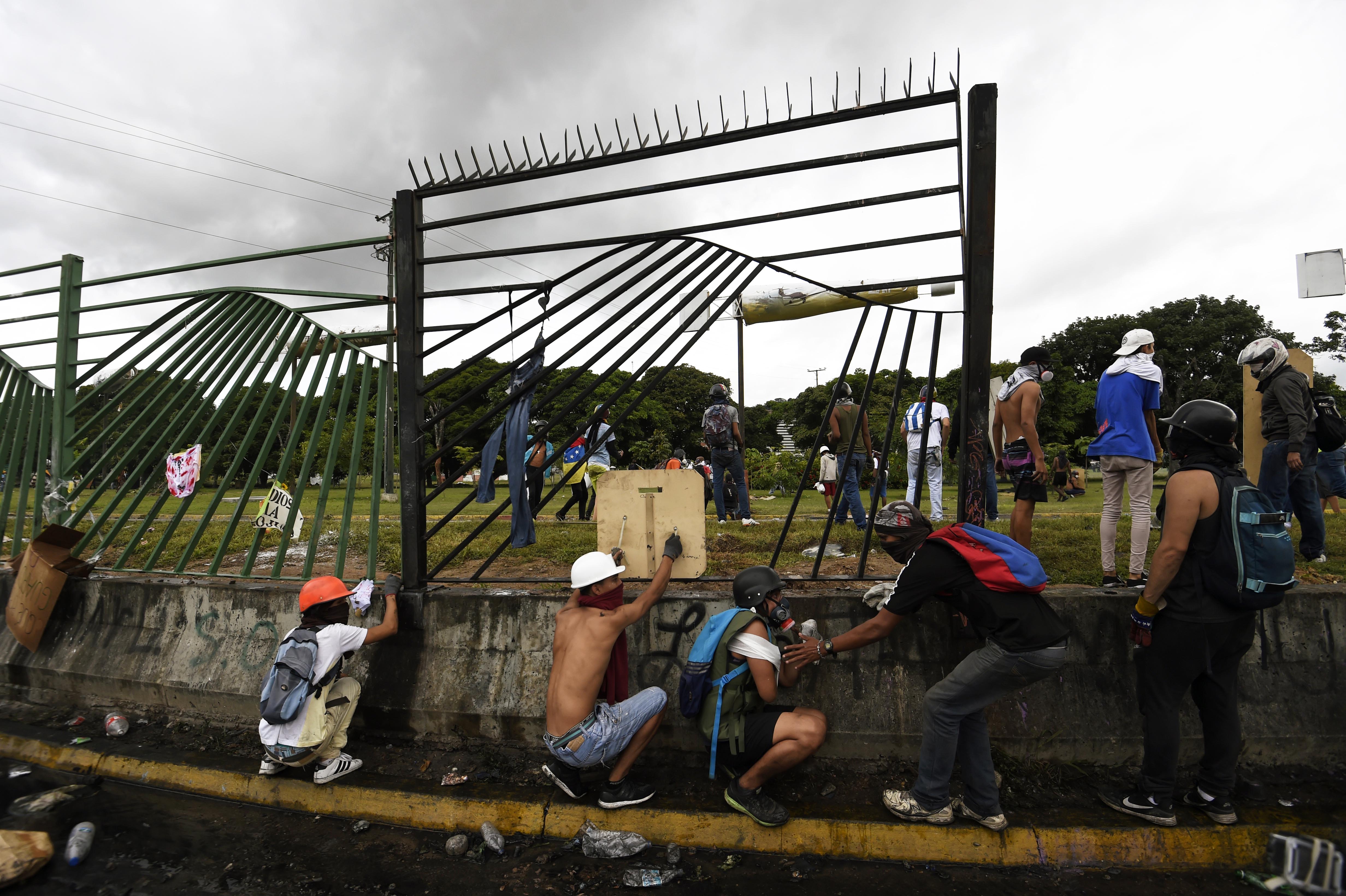 Opositores venezolanos protestan en la valla de la base aérea Francisco de Miranda. (Foto: AFP)