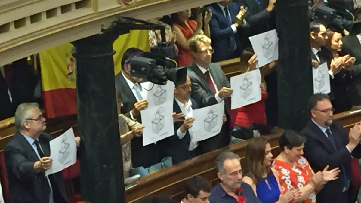 Los diputados del PDeCAT muestran carteles reivindicando el referéndum ilegal ante el discurso de Felipe VI. (Foto: OKD)