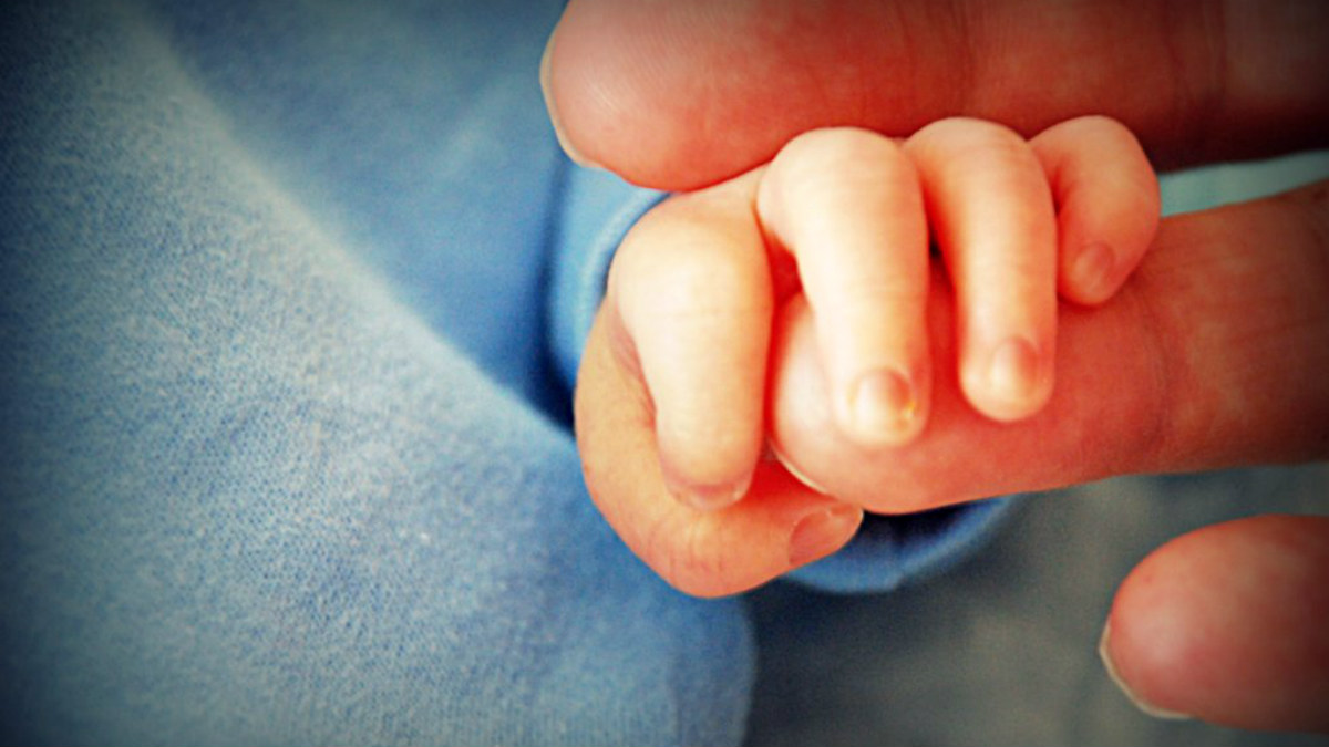 Un bebé agarra el dedo de su padre. (Víctor Nuño / Flickr)