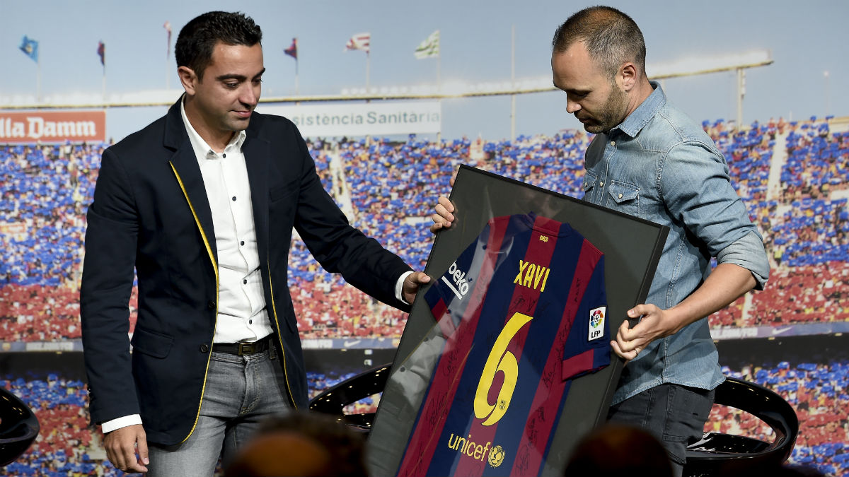 Iniesta le hace entrega a Xavi de una camiseta conmemorativa del Barça.