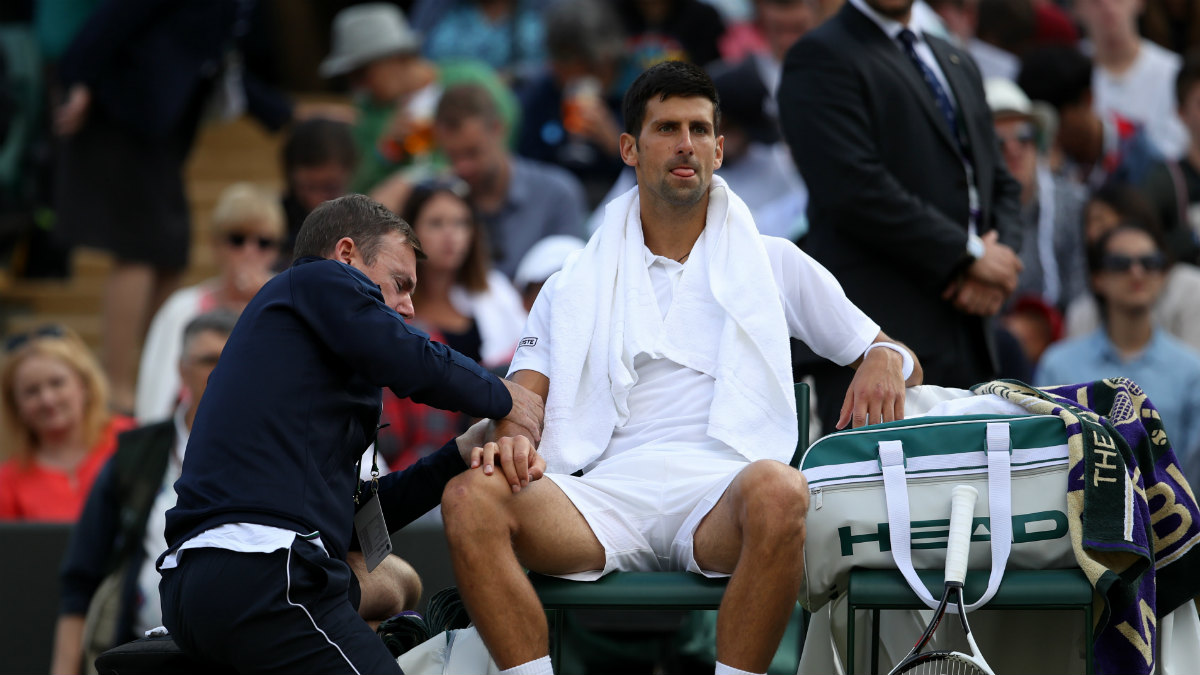Djokovic es atendido de su lesión en el codo en Wimbledon. (Getty)