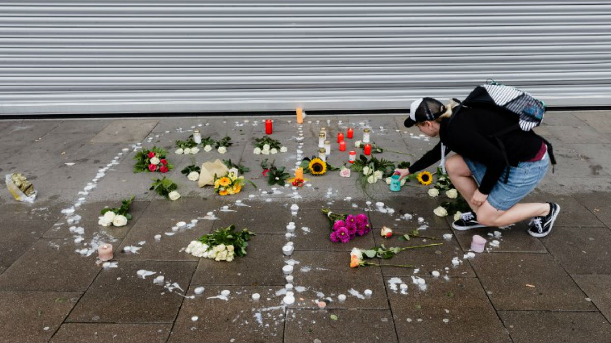 Una mujer deposita una vela en el lugar donde el atacante de Hamburgo acuchilló a una mujer hasta matarla. Foto: AFP