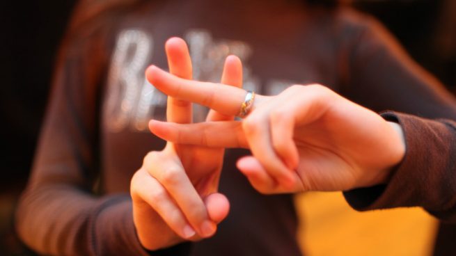 Una joven hace el gesto del 'hashtag' con los dedos.