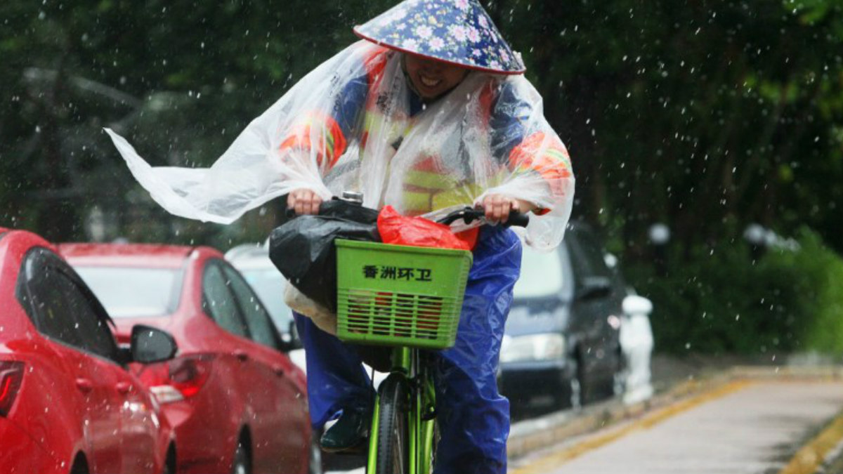 Un japonés anda en bicicleta mientras el tifón Hato hace acto de presencia. Foto: AFP