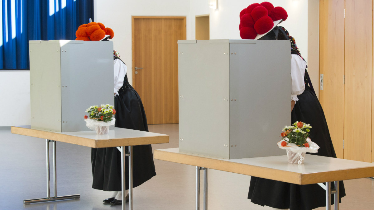 Dos mujeres alemanas votan con el tradicional bollenhut en un colegio de la Selva Negra. (AFP)