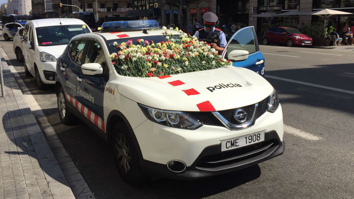 Coche de los Mossos cubierto de claveles