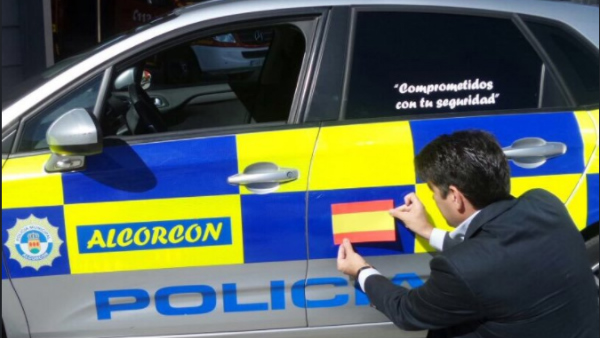 El alcalde de Alcorcón, David Pérez, pegando una Bandera en un coche de Policía Municipal (TW)