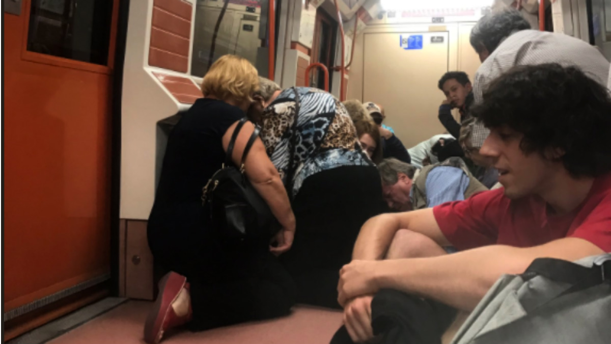 Pasajeros agachados en el vagón tras oír disparos  en el interior del Metro de Madrid.