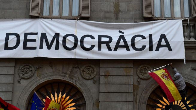 Manifestantes intentan descolgar la pancarta que publicita el referéndum en el Ayuntamiento de Barcelona
