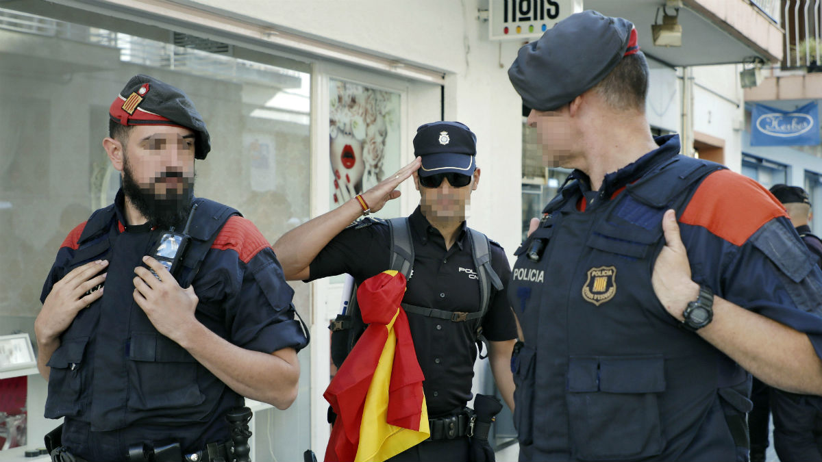 Un agente de la Policía Nacional saluda a dos mossos (Foto: EFE).