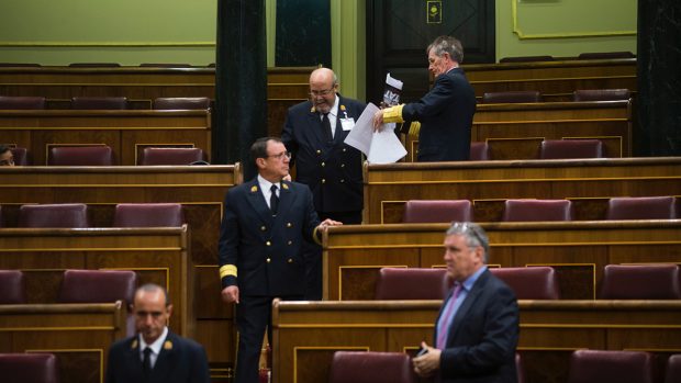 Retirando las fotos en apoyo a los detenidos en Cataluña en los escaños del Congreso. (Foto: FRANCISCO TOLEDO)